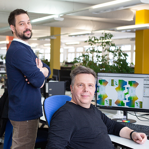 Zwei Personen im Büro vor einer Verpackung auf dem Bildschirm